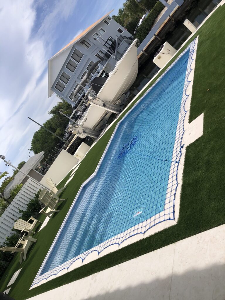 Custom-fitted pool safety net covering a residential swimming pool in Key Largo
