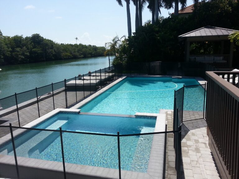 Black removable mesh pool safety fence installed around a residential pool in Key Biscayne