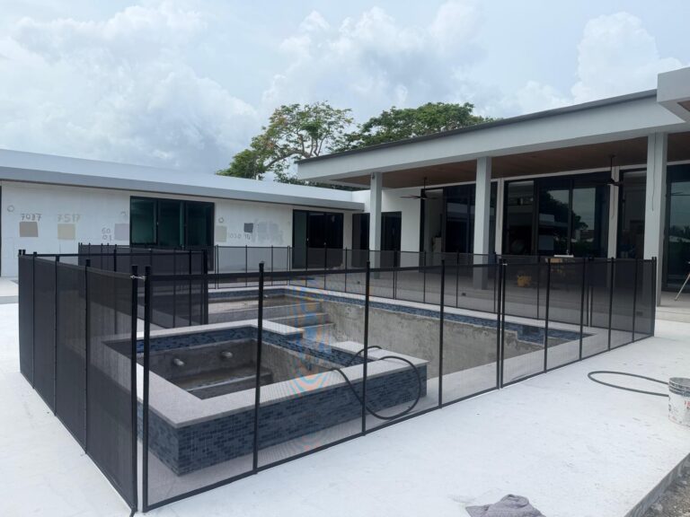Black removable mesh pool safety fence with clean 90-degree corners around a modern pool and spa