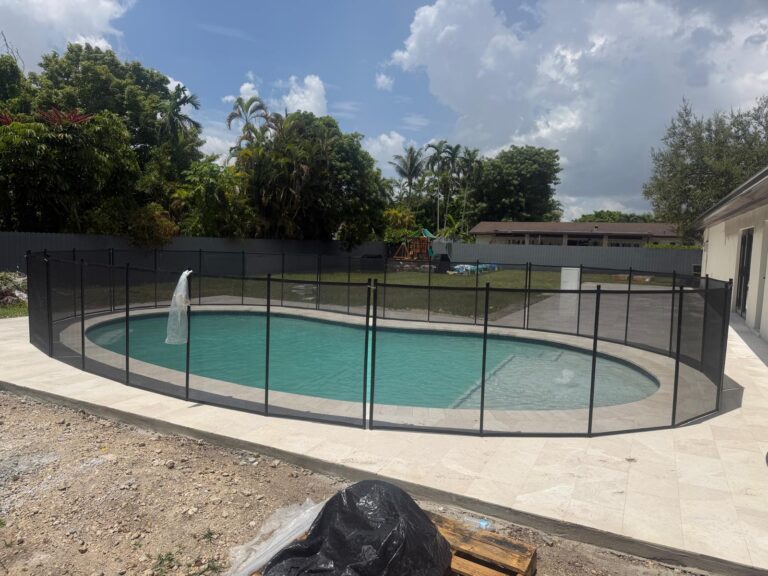 Black removable mesh pool safety fence surrounding a round residential swimming pool