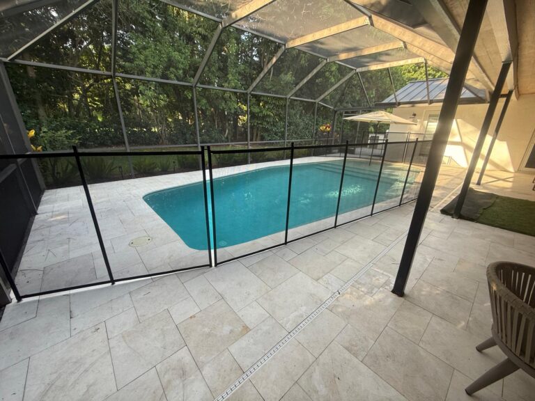 Black removable pool fence connected to a screen enclosure around a pool in Pinecrest