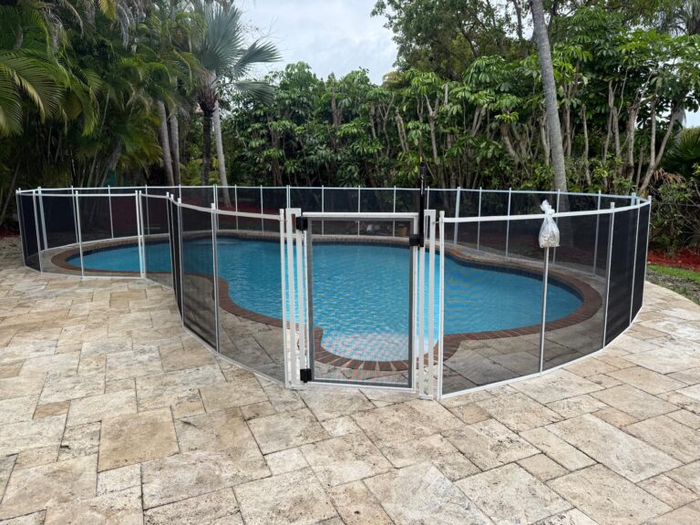 White removable mesh pool safety fence with gate installed around a pool in Coral Gables