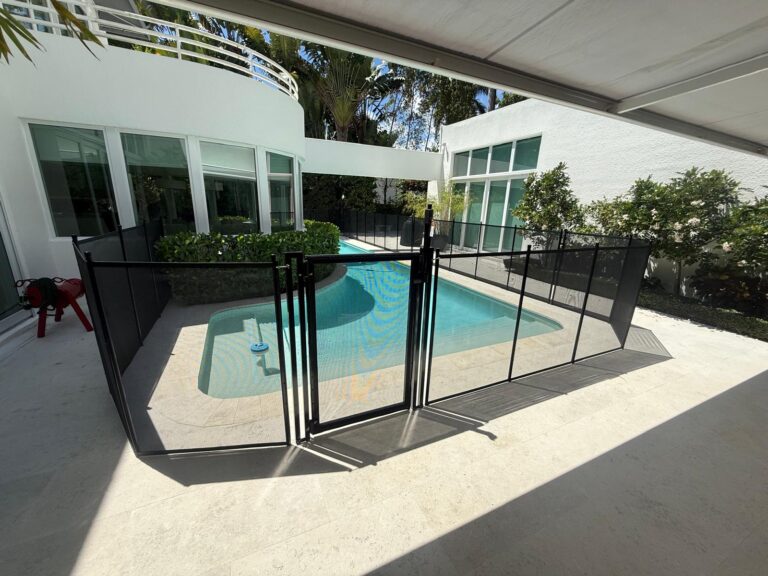 Black removable mesh pool fence with a self-closing safety gate installed around a residential pool