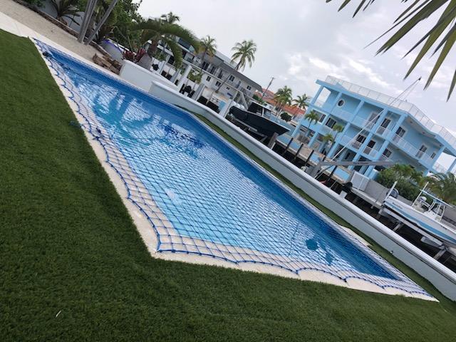 Pool safety net installed over a residential waterfront swimming pool