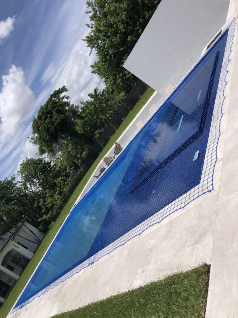 Blue pool safety net covering a large rectangular residential swimming pool