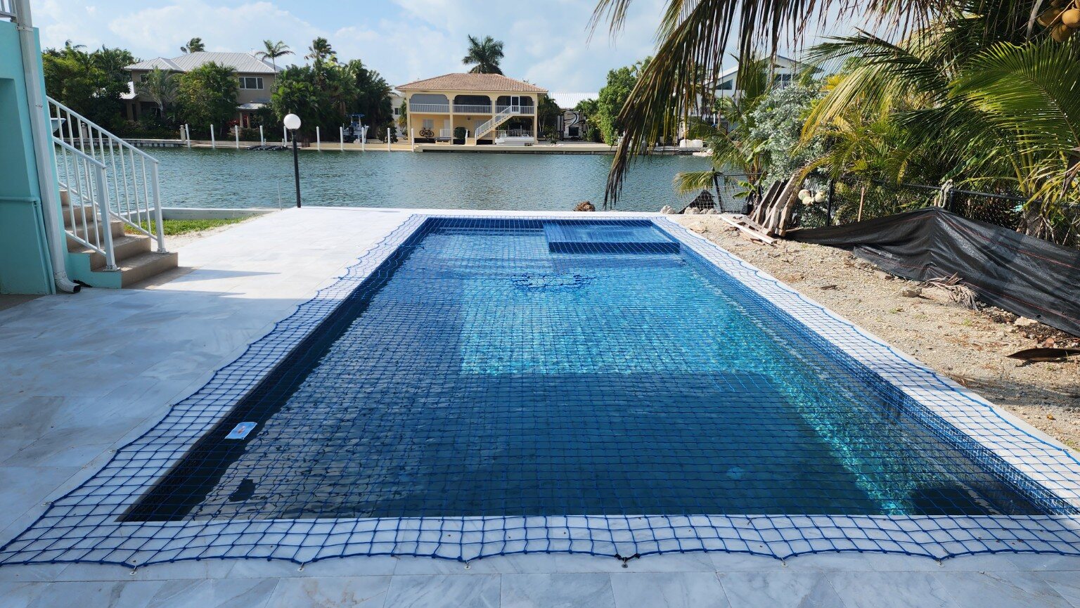 Blue pool safety net installed at a waterfront home in Marathon, Florida Keys
