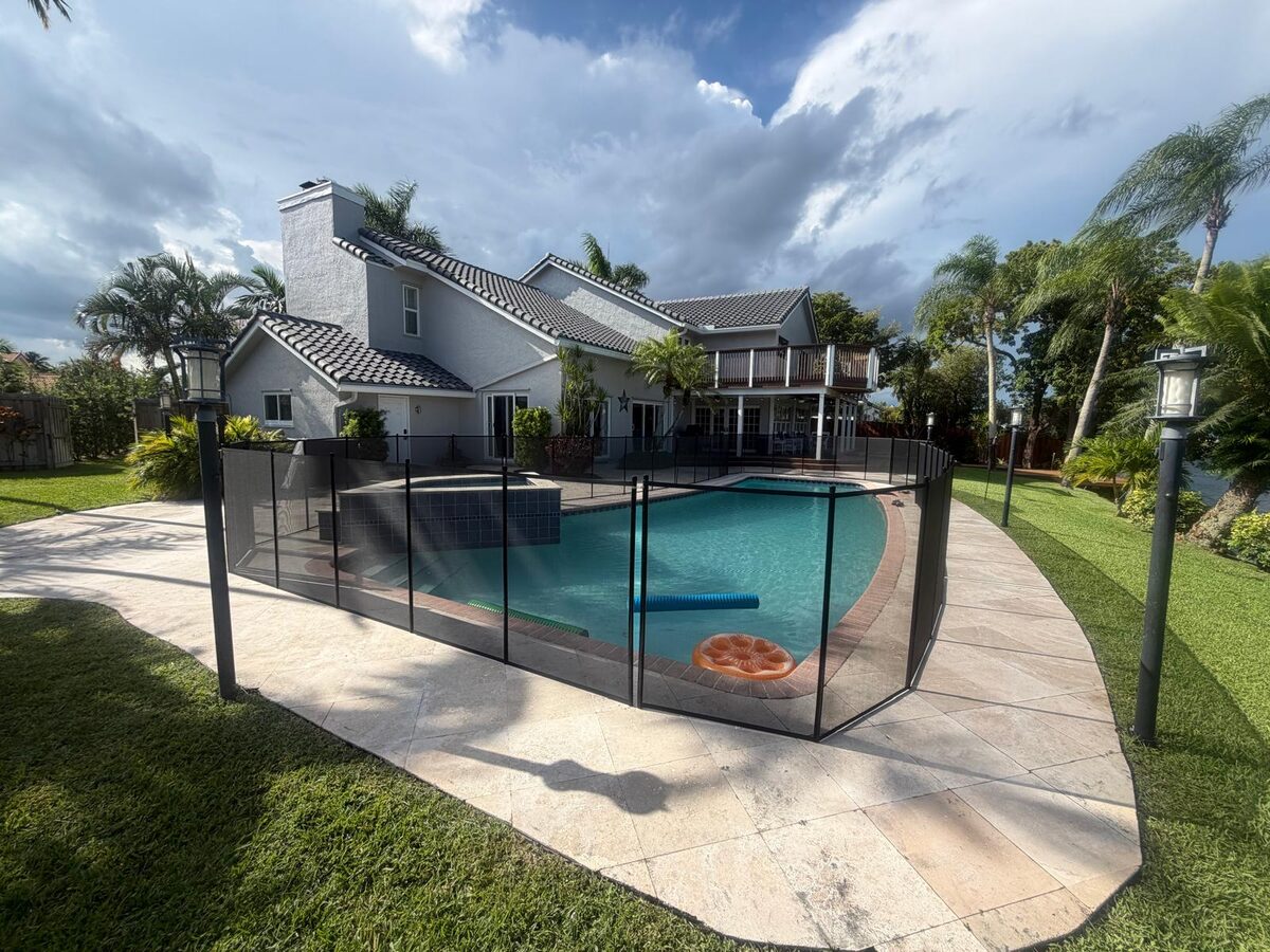 Black removable pool fence enclosing a pool and raised spa in Plantation, Florida