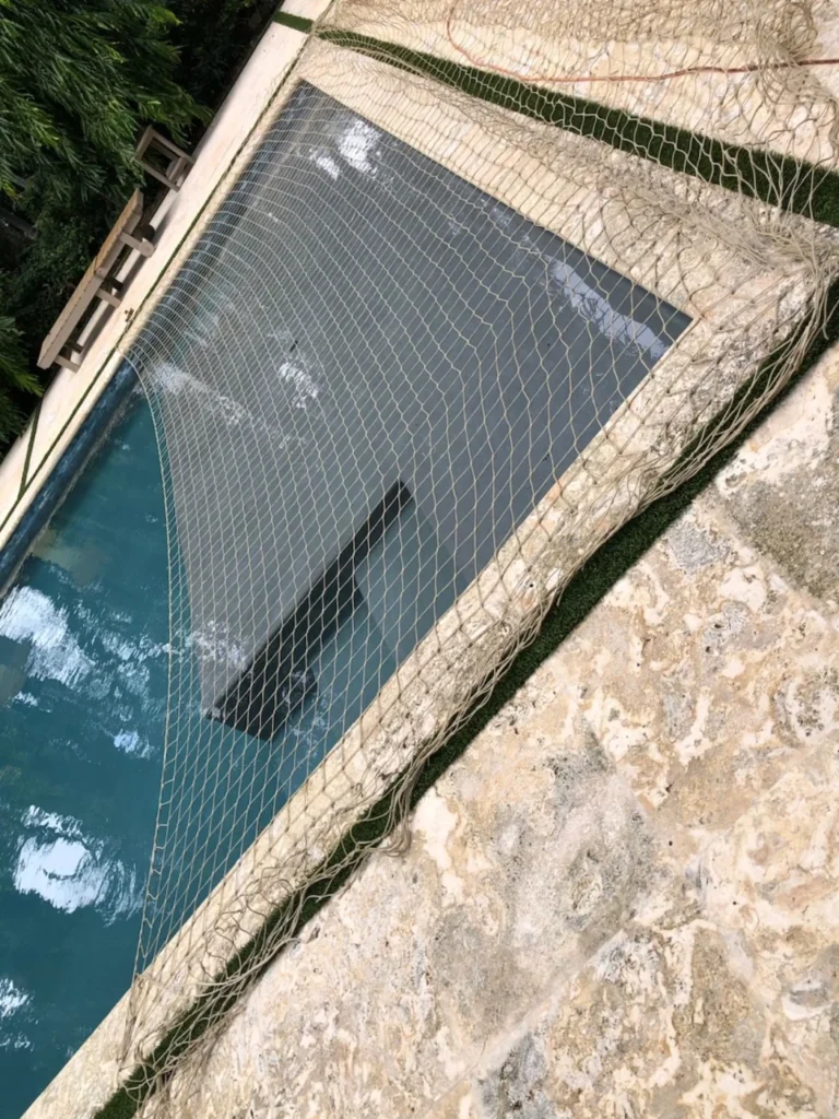Beige raccoon net covering only the shallow area and steps of a swimming pool