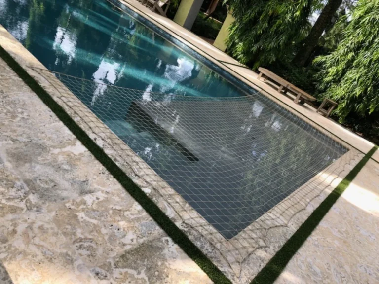 Partial beige raccoon net stretched across the shallow end of a swimming pool